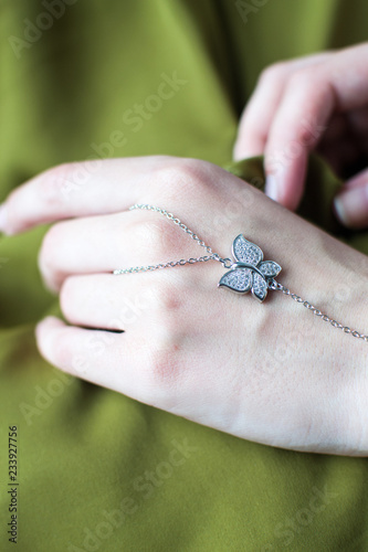 bracelet on hand with butterfly decoration (close up), hand accessories, the bracelet covers finger, womans hands with accessories (vertically)