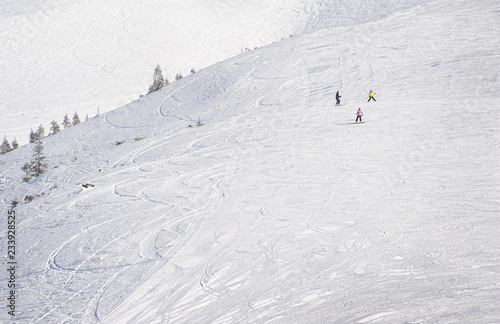 Young snowboarders on ski slope in high mountains. Winter background with snow traces and copyspace