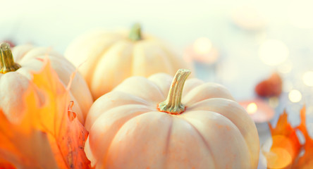 Thanksgiving background. Holiday scene. Wooden table, decorated with pumpkins, autumn leaves and candles