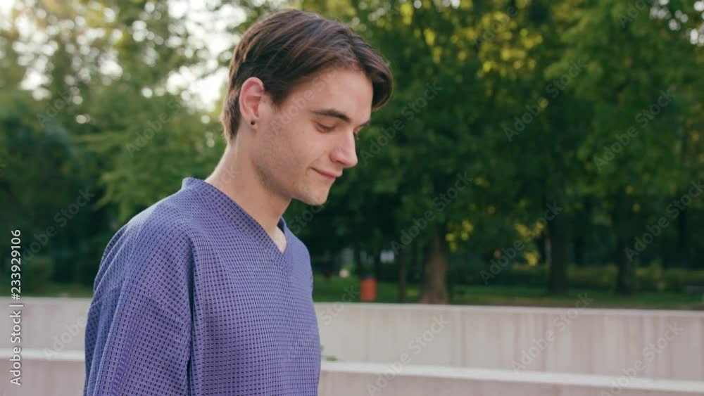 An attractive young man walking and using a phone in town. Close-up dolly shot. Soft focus An attractive young man walking and using a phone in town. Close-up dolly shot. Soft focus
