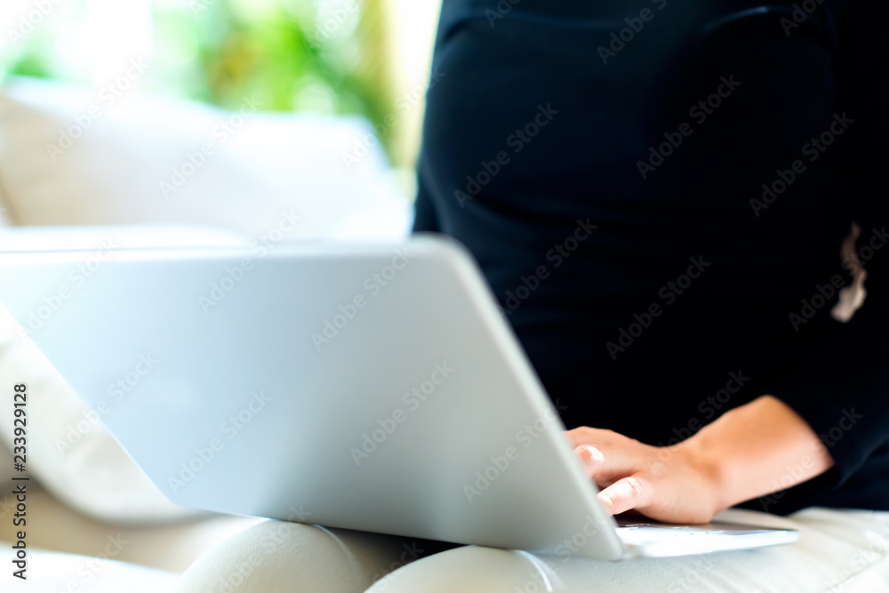 Young woman with a laptop computer in a bright interior room Young woman with a laptop computer in a bright interior room