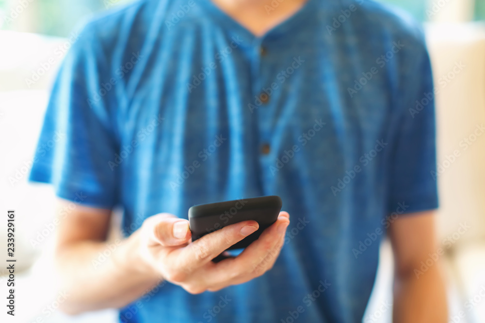 Young man using his smartphone in a bright interior room Young man using his smartphone in a bright interior room