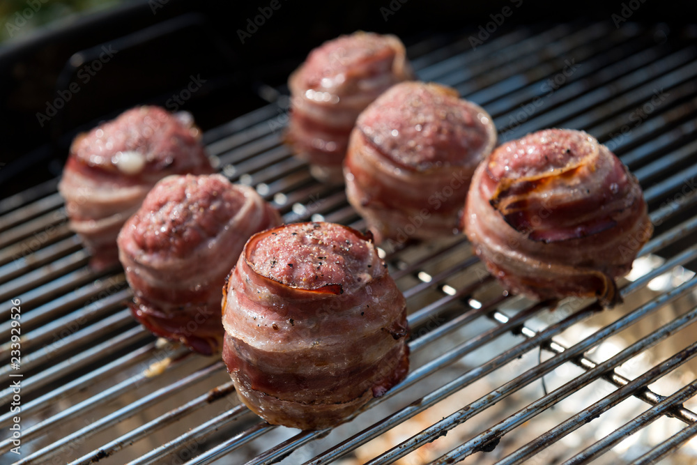 Cooking meatballs covered with bacon on the grill Cooking meatballs covered with bacon on the grill