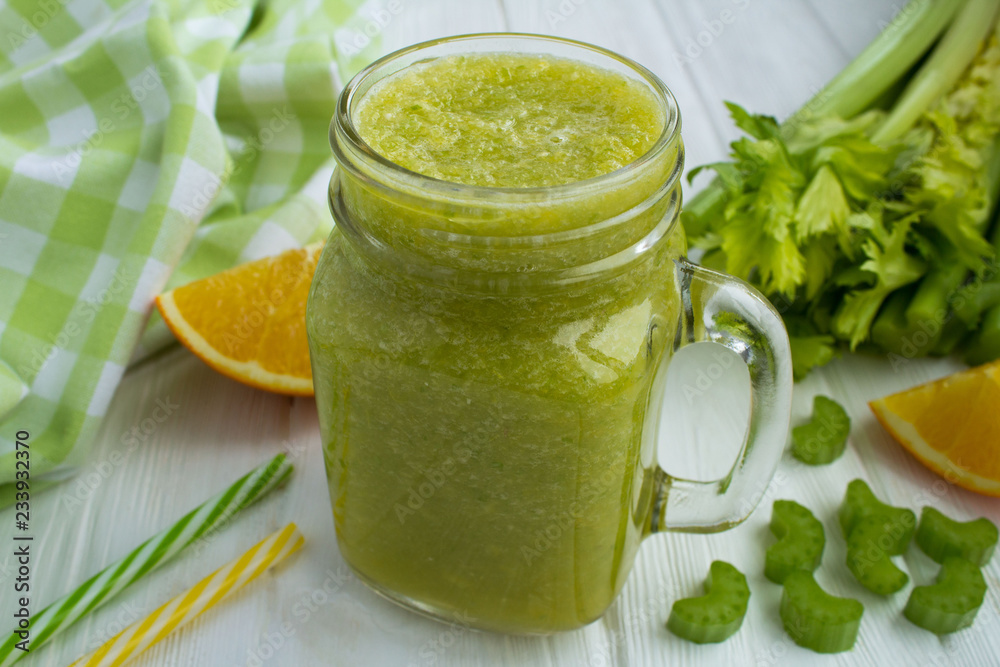 Smoothies with orange and celery on the white wooden background Smoothies with orange and celery on the white wooden background