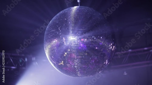 Mirror disco ball at the party. Rotates, reflecting the rays of light from the spotlights.