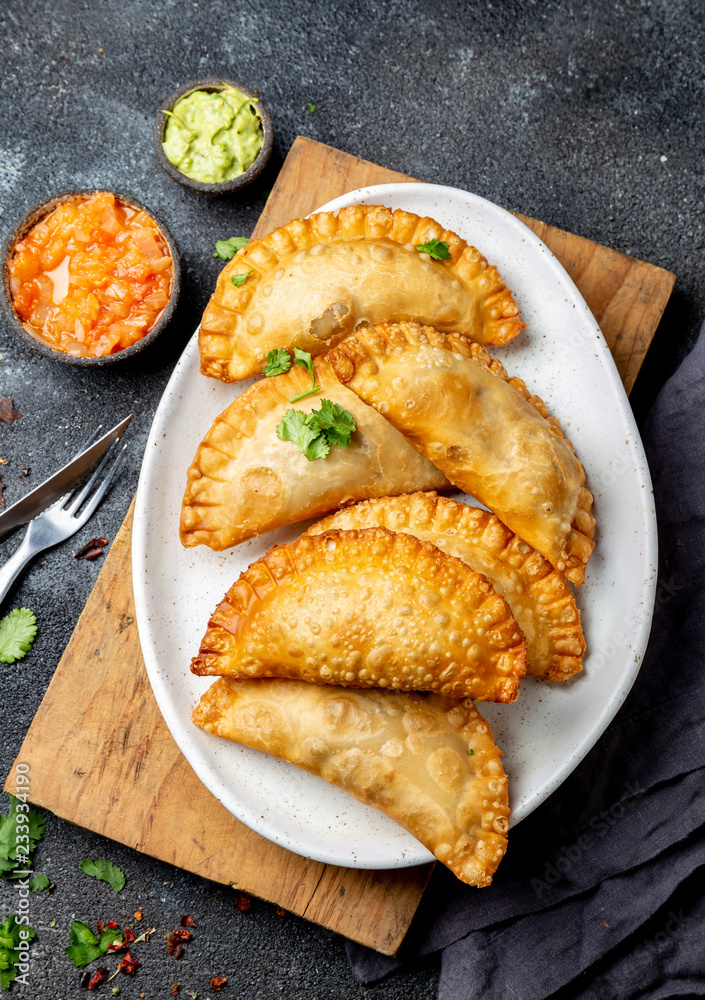 Latin American fried empanadas with tomato and avocado sauces. Top view Latin American fried empanadas with tomato and avocado sauces. Top view