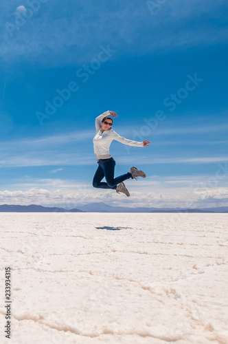 Girl in a jump in sunshine Salar de Uyuni