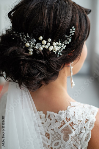 closeup of a hair clip of beads and pearls in the hair of the bride. wedding hairstyle, morning of the bride