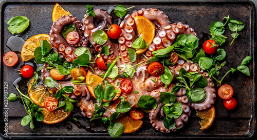 Fototapeta Naklejka Na Ścianę i Meble -  Whole octopus salad with orange, tomatoes and cress salad served on board with wine