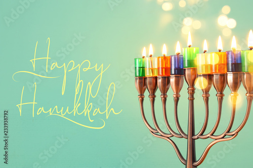 image of jewish holiday Hanukkah background with menorah (traditional candelabra) and colorful oil candles.