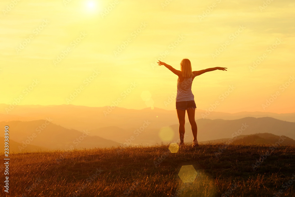 Happy woman with open arms stay on the peak of the mountain Happy woman with open arms stay on the peak of the mountain