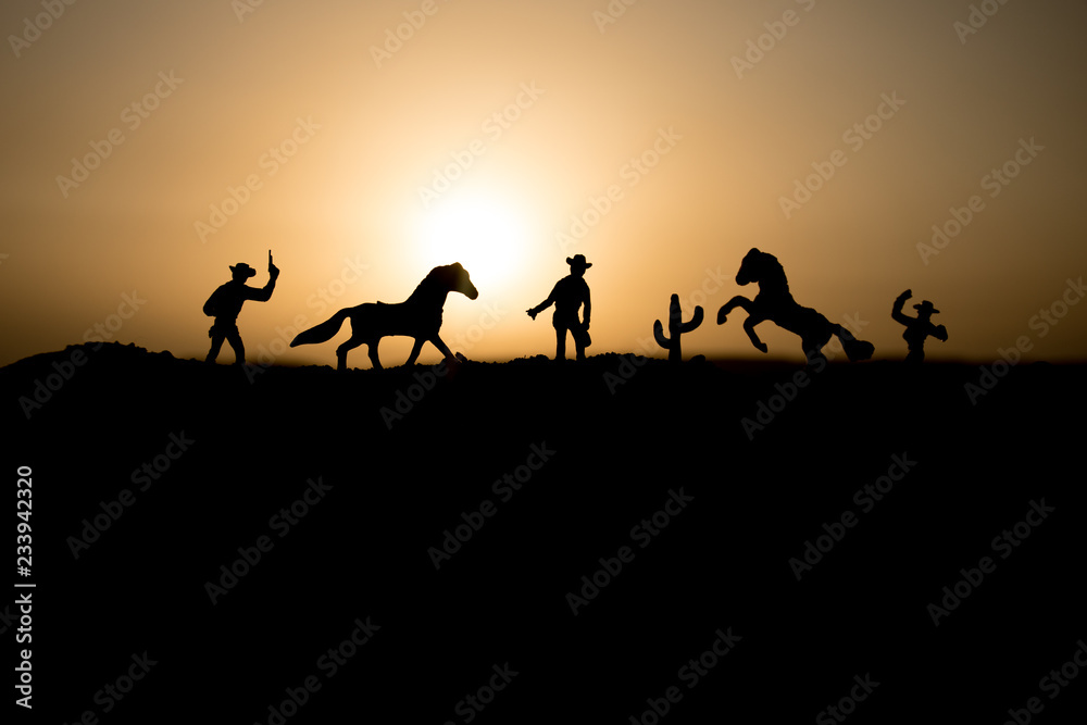 Cowboy concept. Silhouette of Cowboys at sunset time. Cowboys silhouettes on a hill with horses. Cowboy concept. Silhouette of Cowboys at sunset time. Cowboys silhouettes on a hill with horses.