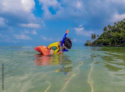 Boy wearing a life jacket, scuba diving in the sea at Haad salad Beach , koh Phangan  Suratthani Thailand.