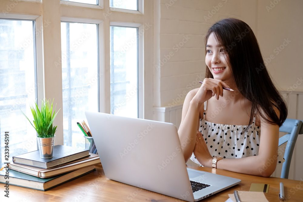 Beautiful Young woman working on laptop and computer at home Beautiful Young woman working on laptop and computer at home