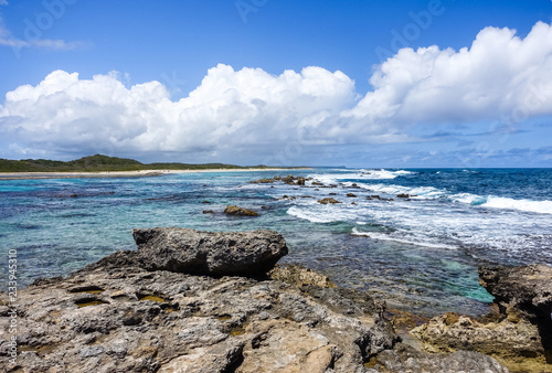 Caribbean Seascape with Blue Cloudy Sky and Rocky Beach