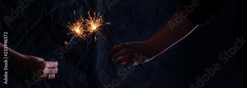 Christmas Decoration Banner - Hands with sparklers. The atmosphere of the festive party.