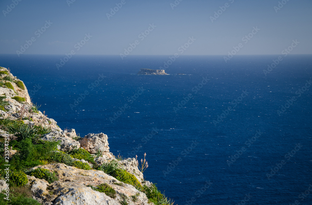 View of limestone rock, Mediterranean sea and Filfla island, Malta