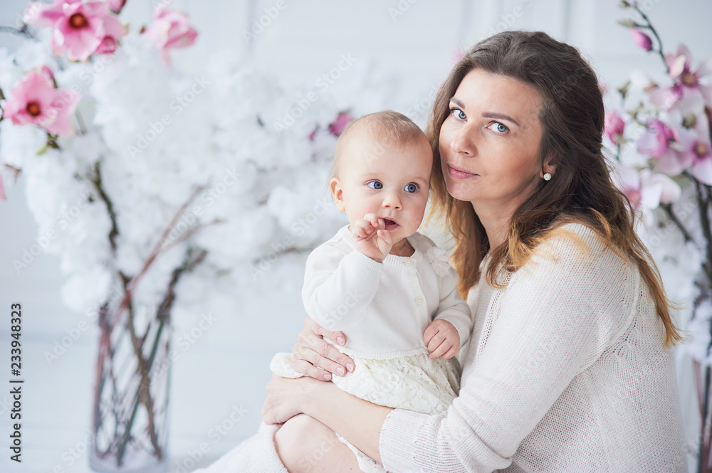 beautiful young mother with a baby in her arms is standing The concept of a happy family, motherhood
