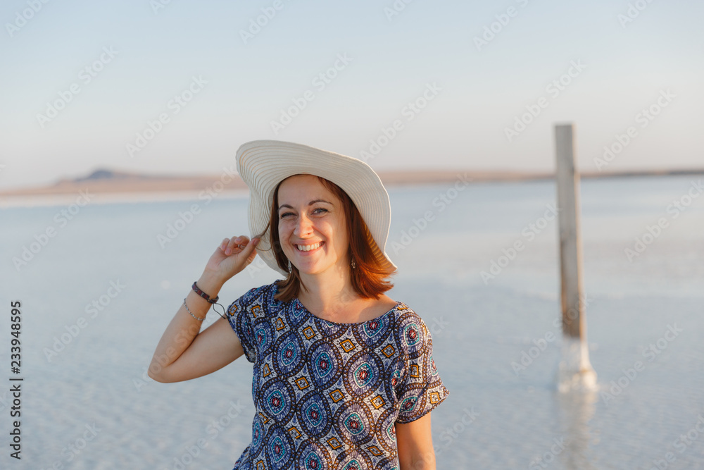 happy smiling girl in white hat enjoying sun, expanse of Bascunchak salt lake