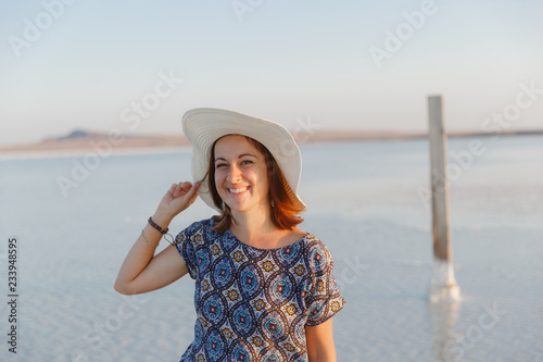 happy smiling girl in white hat enjoying sun, expanse of Bascunchak salt lake