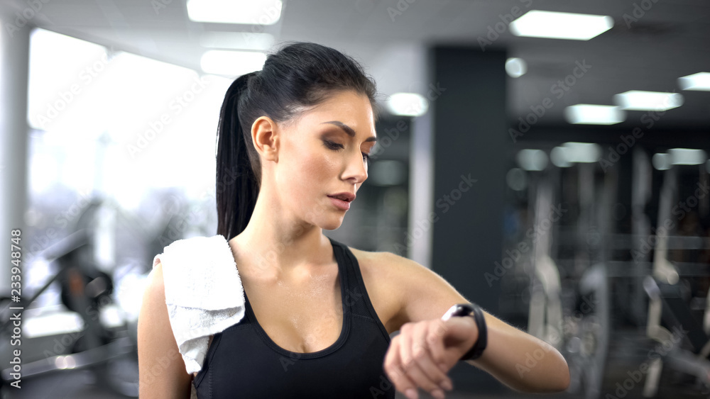 Fototapeta premium Sport woman checking pulse and burned calories in smartphone, modern technology