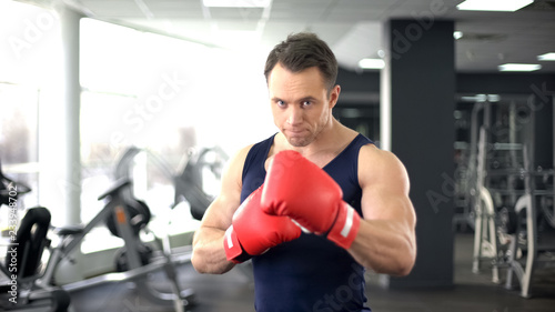 Sportsman in boxing gloves ready for training, fight spirit, sport confidence © motortion