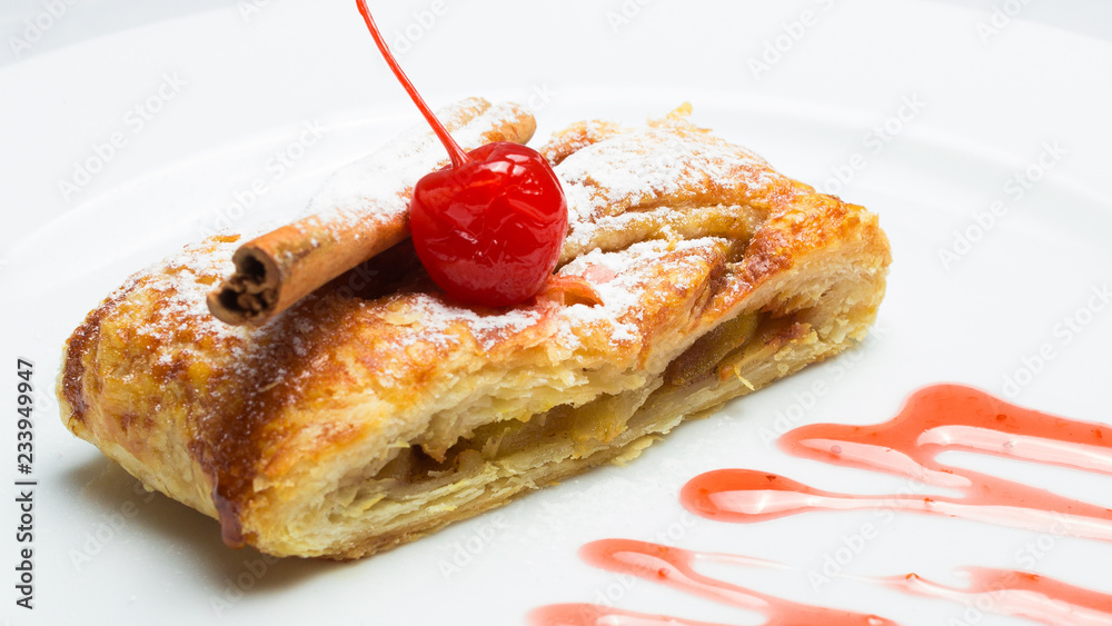 sweet strudel with berries and filling on a white plate