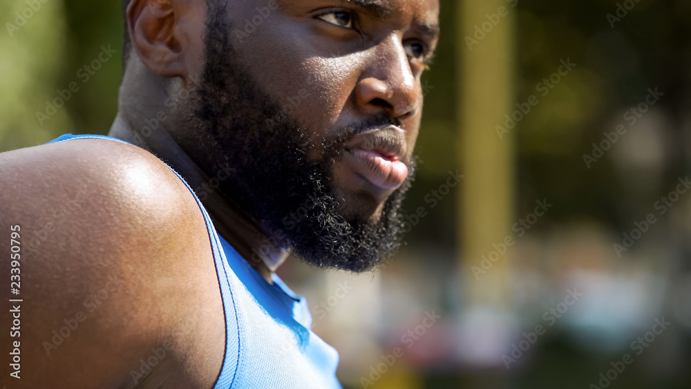 Strong bearded Afro-American sportsman seriously looking forward, close-up