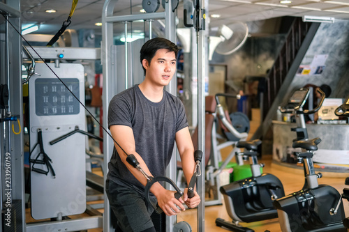 Asian man exercising at gym.