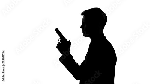 Male silhouette holding gun, preparing to shoot, revenge, contract killing