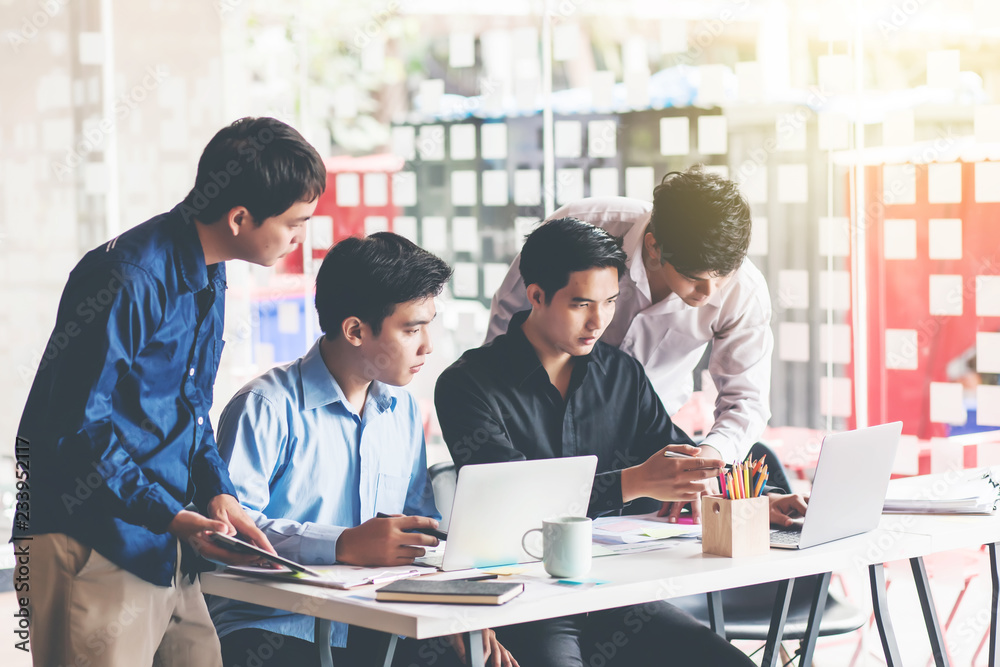 Groups of young men who talking together to discuss the work in the workplace. Groups of young men who talking together to discuss the work in the workplace.