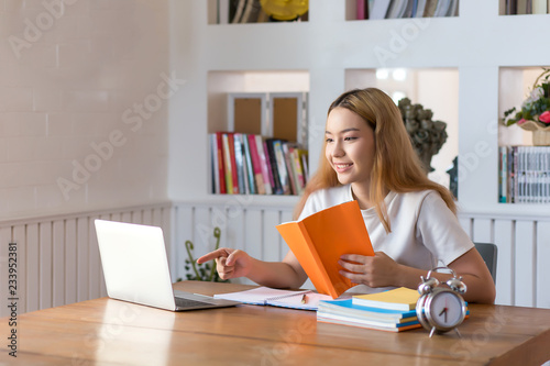 Young woman student working on laptop sitting in library at home © amnaj