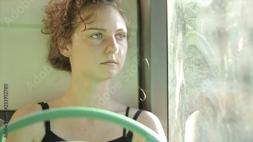 Girl alone riding on city bus. Reflection in the window.