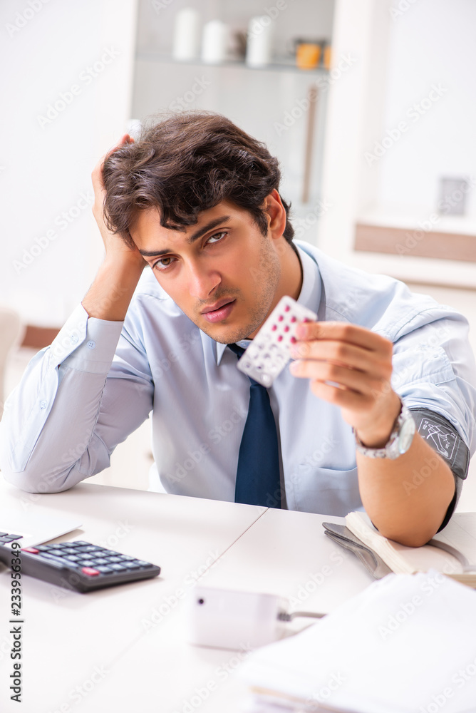 Man under stress measuring his blood pressure Man under stress measuring his blood pressure