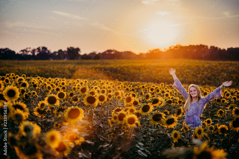 woman in a sunflower field at sunset