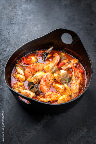 Traditional French Corsican seafood stew with prawns, mussels and fish as top view in a modern design Japanese cast-iron roasting dish