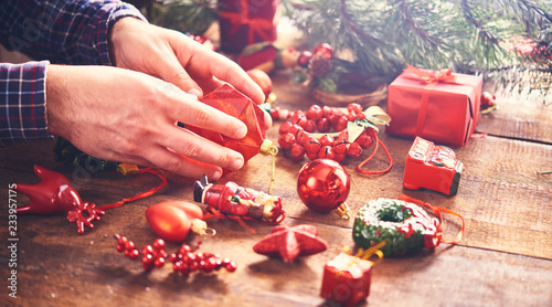 Christmas preparation concept. Man's hands holding decorations