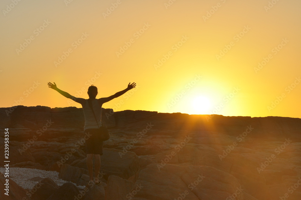 Young isolated man's silhouette with outstretched raised hands at sunset, sun rays flare on camera. Traveling and Mindfulness icons