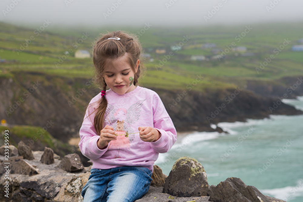 portrait of a little girl on the background of the ocean, ring of Kerry, Ireland
