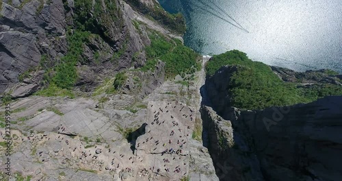 A lot of tourists are on Preikestolen famed 604-metre cliff with flat top. Natural attraction also known as Preacher's Pulpit, Preacher’s Chair in Rogaland, Norway. Top view from drone