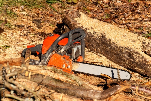 The chain saw lies on wood. Wood preparation for heating. Ecological heating. Working with the saw. Gasoline Saw.