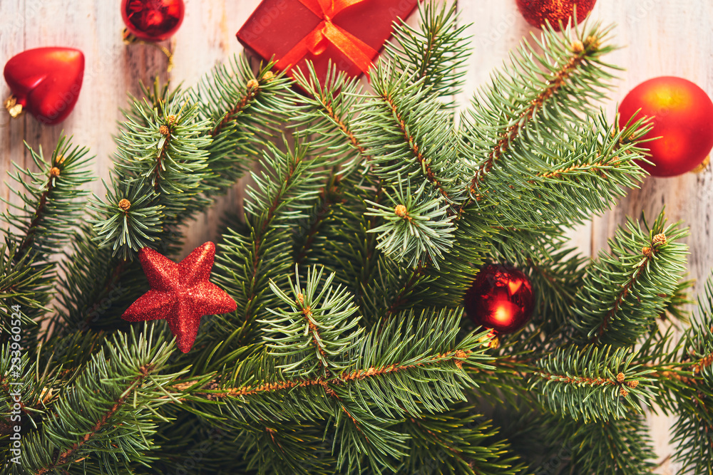Christmas background. Fir tree and a lot of christmas red baubles and gift box Christmas background. Fir tree and a lot of christmas red baubles and gift box