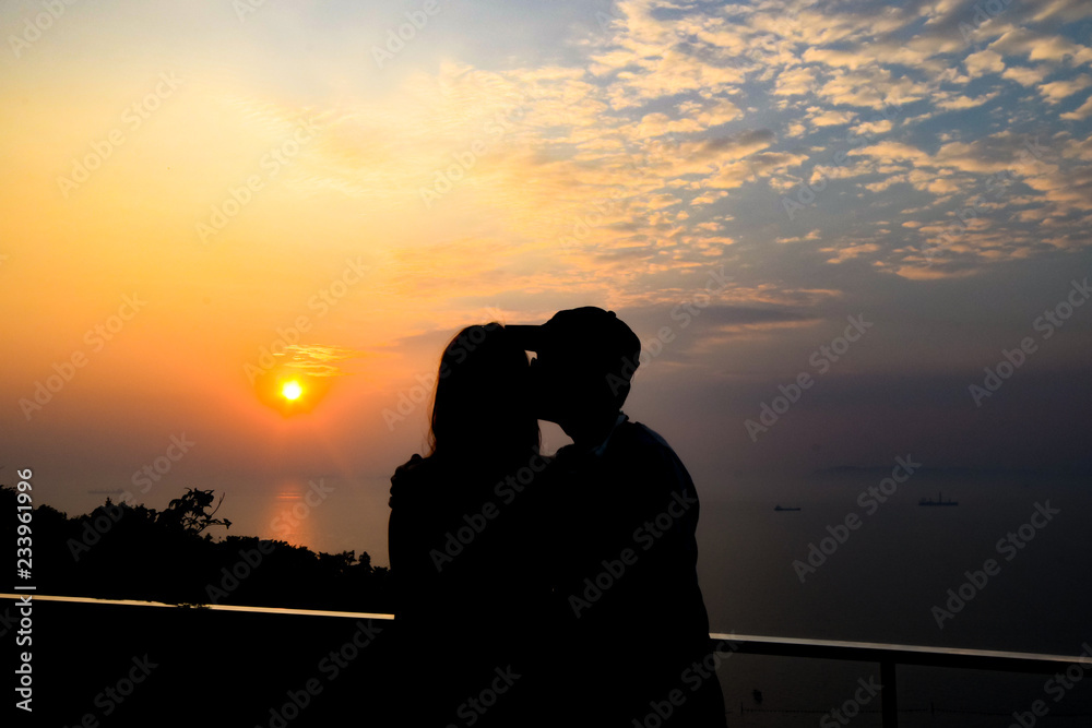 Silhouette couple on the view point to watch sunset