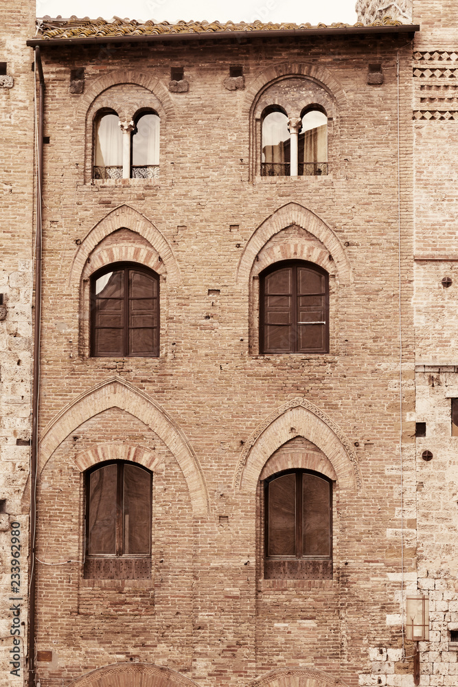 Closeup view of old stone house in San Gimignano. Tuscany, Italy. Vertically. Edited as a vintage photo.