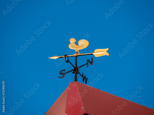 Image of a golden weathercock on a roof photo