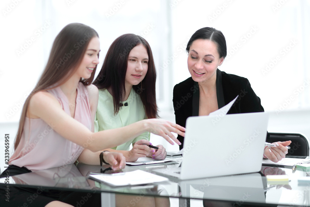 three business women discussing work issues in the office three business women discussing work issues in the office