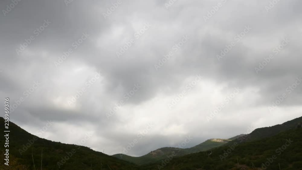 Mountains in the background of gray clouds. sun's rays run along the ridges. Dark clouds envelop the tops of the mountains. Time Lapse. Motion in the frame. Beautiful alluring landscape. Mountains in the background of gray clouds. sun's rays run along the ridges. Dark clouds envelop the tops of the mountains. Time Lapse. Motion in the frame. Beautiful alluring landscape.