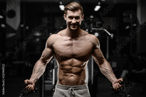 sexy strong bodybuilder athletic men pumping up muscles with dumbbells