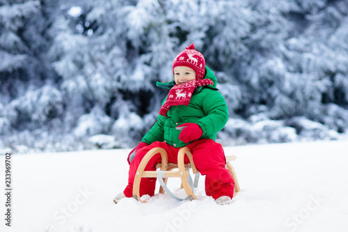 Boy on sleigh ride. Child sledding. Kid with sledge © famveldman