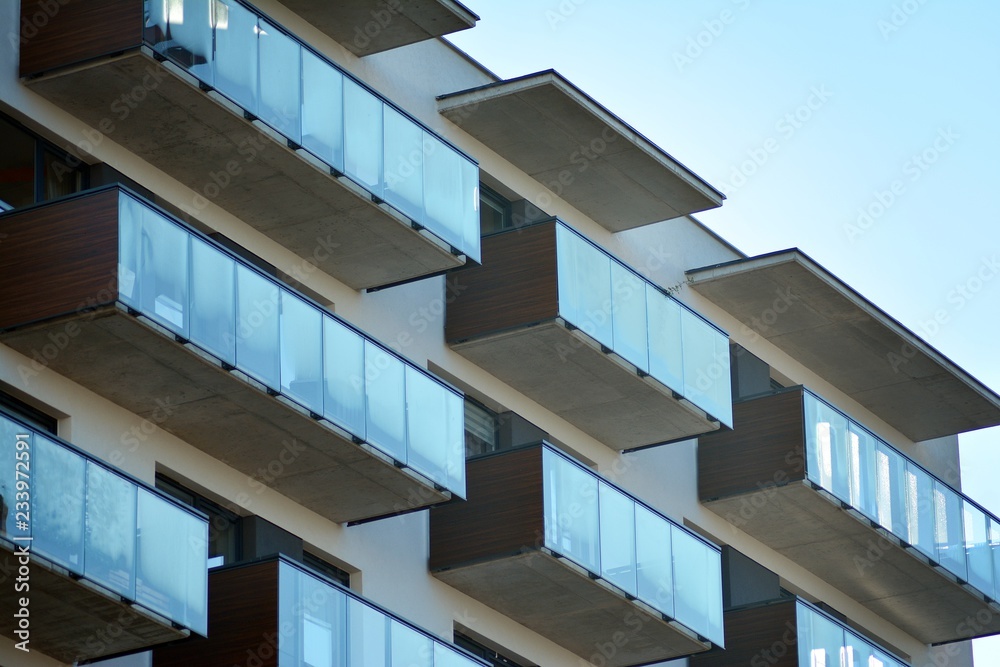 Fragment of a facade of a building with windows and balconies. Modern home with many flats. Fragment of a facade of a building with windows and balconies. Modern home with many flats.